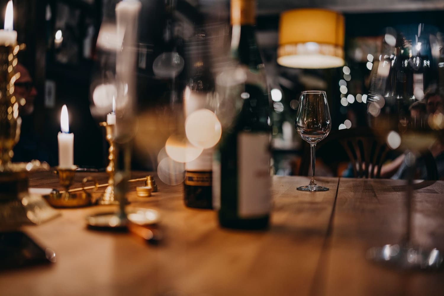 Mesa posta com dois copos de vinho, à luz do fim de tarde